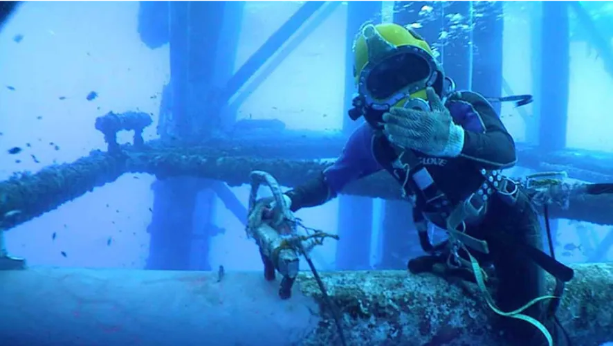Plongeurs professionnels nettoyant une coque de navire sous-marine